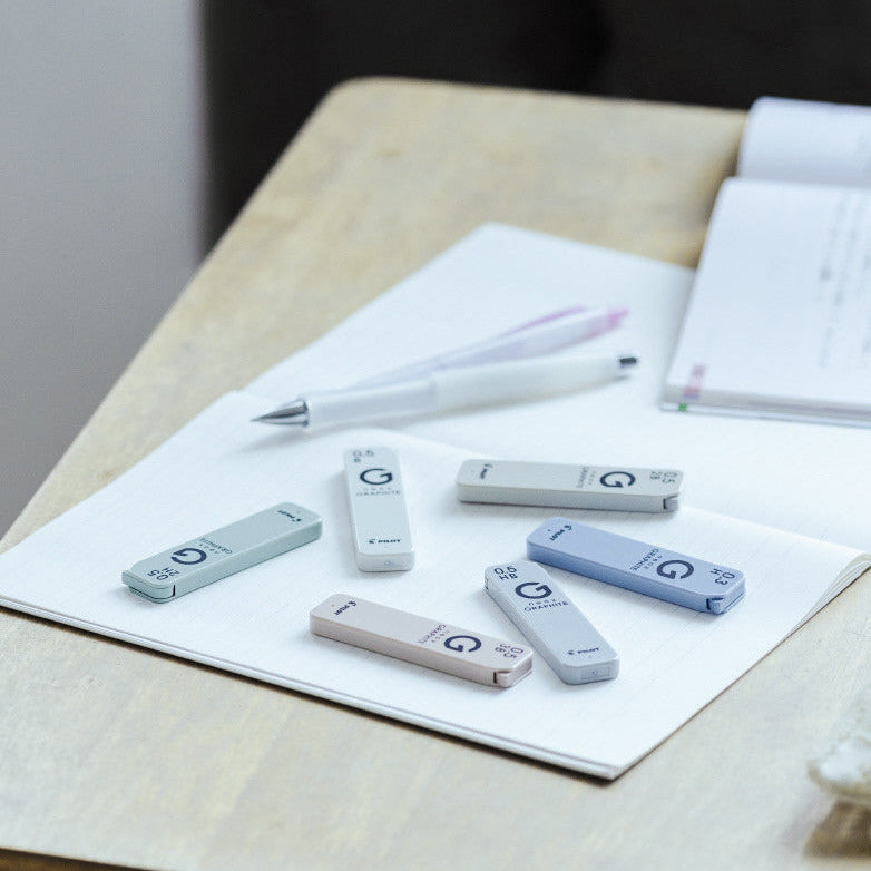 Small electronic devices on a piece of paper with a pen on a wooden surface.