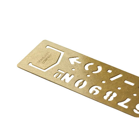 Gold metal ruler with numbers and letters on a white background
