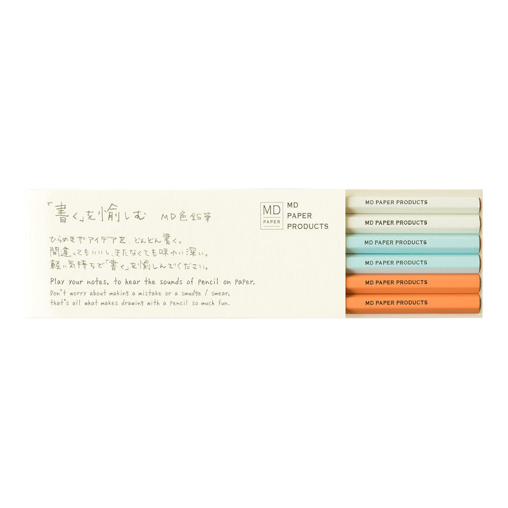 A set of six MD Midori color pencils in gray, light blue, and orange, packaged in a sleek, beige box with Japanese text.